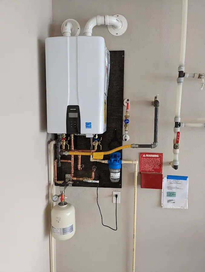 Professional plumber installing copper piping in a Johnson home